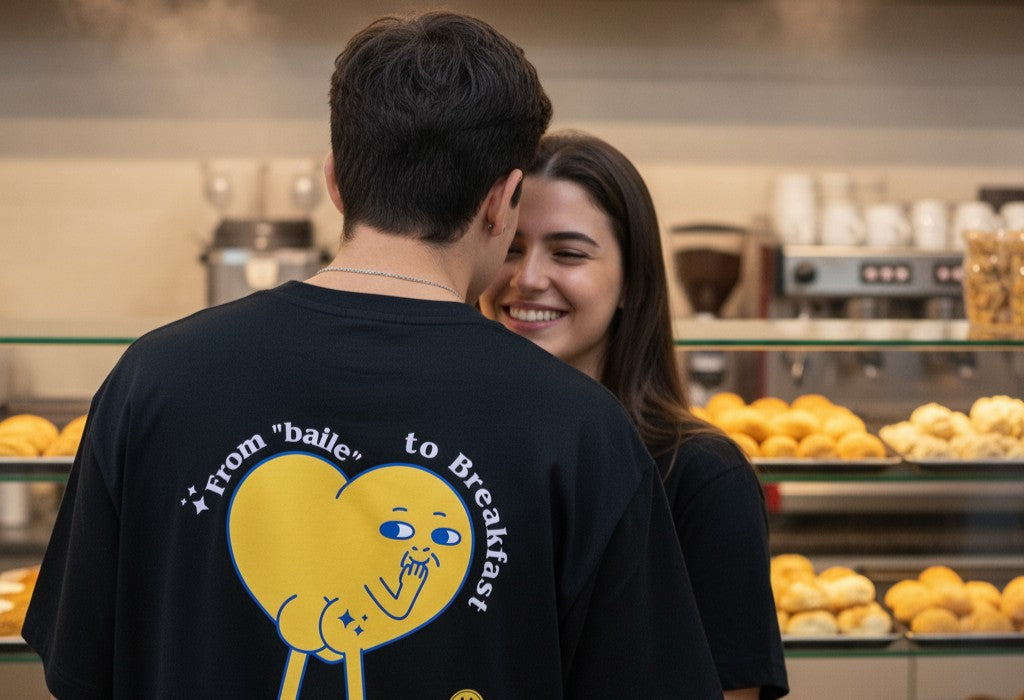 A smiling couple in a bakery with a 'From baile to Breakfast' t-shirt